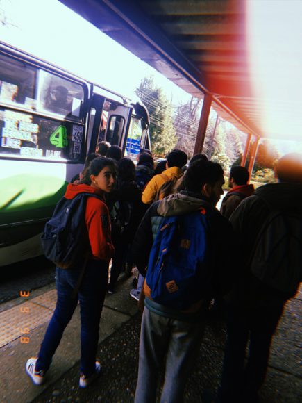 Estudiantes haciendo la fila para tomar la micro 4 en la hora de almuerzo.