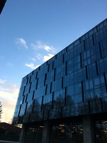 Edificio Pugin, reflejando el cielo azul y gente disfrutando del sol de primavera.